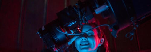 A student looks through a telescope viewfinder.
