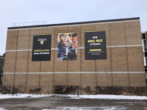 Banners celebrating Donna Strickland adorn the exterior wall of the Physics building.
