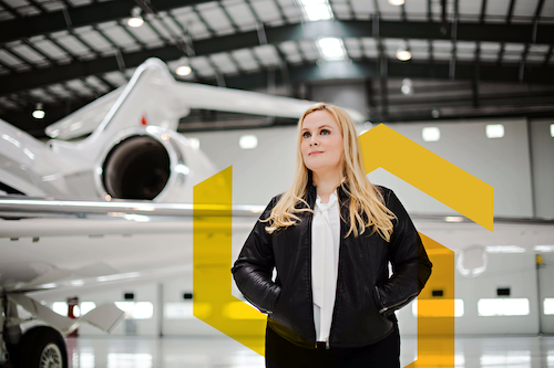 Dr. Suzanne Kearns stands near an airplane in a hangar.