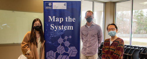 People stand next to a Map the System Zap banner.