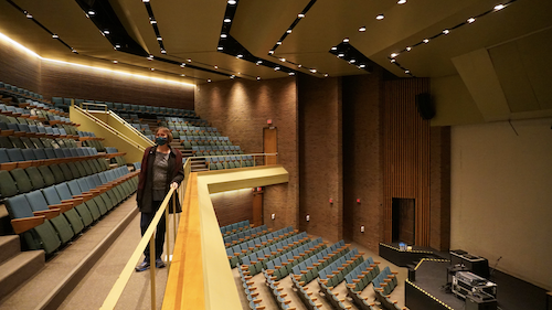 Janelle Rainville stands at the balcony of the Humanities Theatre's upper level.