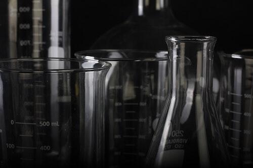 A close-up of laboratory glassware shrouded in darkness.