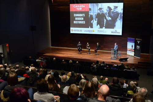 Panelists at the Canada 150 Hidden Histories lecture speak on stage.