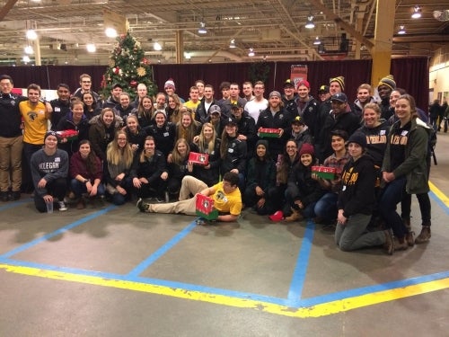 Members of the Warriors sports team pose at the Operation Christmas Child warehouse with shoe-boxes.