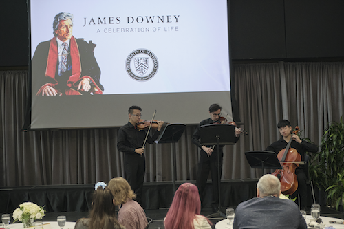 Waterloo students Frank Wang, Robert Choi and Shayan Saebnoori perform with string instruments on stage.