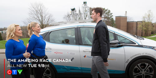 Amazing Race contestants stand in front of an autonomous vehicle