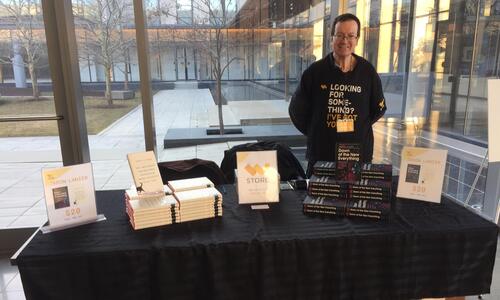 Gord HIgginson stands behind a table that has books on display