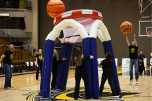 An inflatable basketball net apparatus at half court.