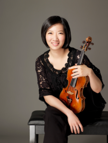 Jung Tsai, violinist, poses with her violin.