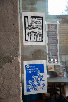 Protest stickers and flyers in a shop window.