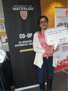 A student poses with a Waterloo Co-op banner.