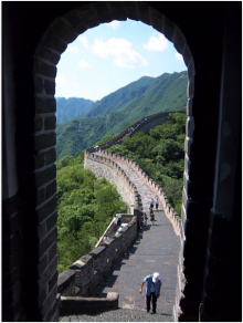 A portion of the Great Wall of China viewed through a stone arch.