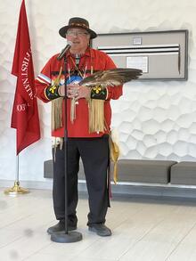 Myeengun Henry conducts a ceremony while holding an eagle feather.