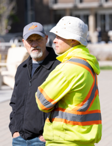 Dennis Huber (left) speaks with a Plant Operations worker.