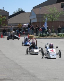 Electric vehicles race in a parking lot.
