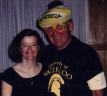 Burt Matthews in UW-branded golf hat and gear poses with a woman.