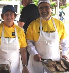 Feridun Hamdullahpur and a volunteer serving burgers at the Keystone Picnic.