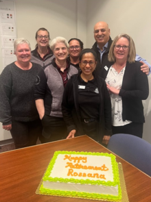Rossana Frowd pictured with her colleagues and a cake wishing her a happy retirement.