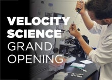 A person performs a science experiment with the words &quot;Velocity Science Grand Opening&quot; superimposed.