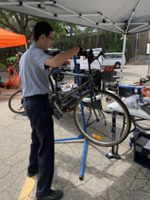 A technician repairs a bicycle on a stand.