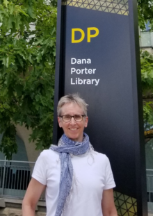 Jane Forgay stands in front of the Dana Porter Library sign.