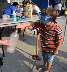 A child inspects a cloud in a bottle.