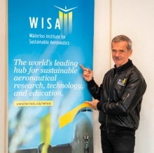 Chris Hadfield points at a WISA conference banner.
