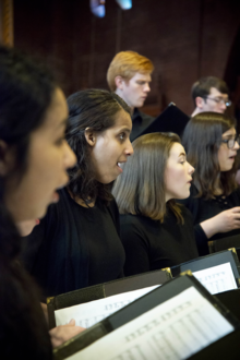 A profile shot of singers in the Chamber Choir singing.
