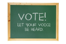 A blackboard slate with the words &quot;VOTE! Let your voice be heard.&quot;