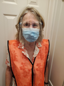 Professor Sally Gunz in an orange vest and PPE including face shield.