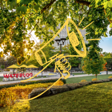 A campus scene with an illustration of a person holding a megaphone.