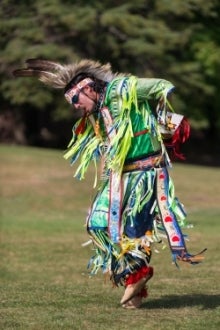 An Indigenous performer in traditional garb.