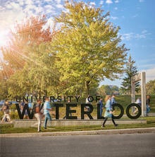 Students walk past the South Campus Entrance sign in fall.