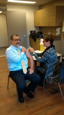 Feridun Hamdullahpur receives a flu vaccine injection.