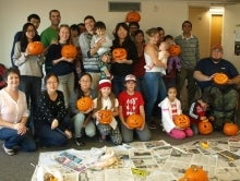 Members of the International Spouses Club hold their carved pumpkins