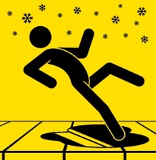 A warning sign featuring a stick figure slipping on a patch of ice.