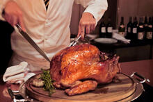 A chef carves a roasted turkey.
