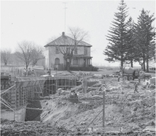 The Graduate House as it appeared in 1957 as construction on the first campus building took place nearby.