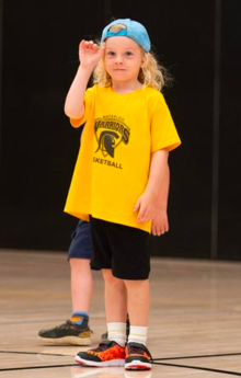 A child wearing a yellow University of Waterloo shirt waves at the camera.