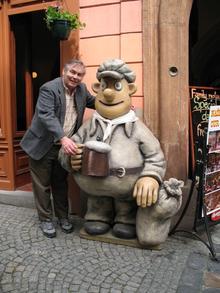 Professor Gentleman poses with a statue in Prague.