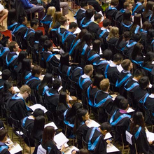 Graduands in their regalia sit during a convocation ceremony.