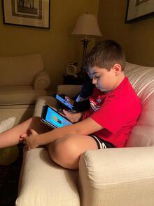 Two boys play with tablet devices.