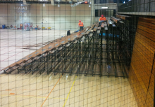 Workers remove the slats from the folding bleachers.