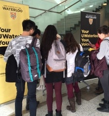 Students crowd around a kiosk.