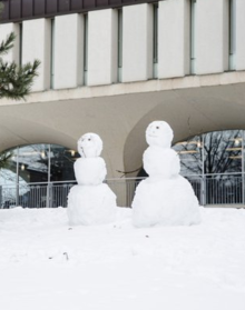 Two snowmen on the lawn of the Dana Porter Library.