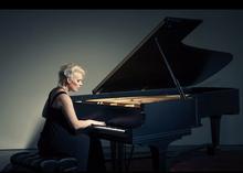 Heidi Wall sits and plays at a grand piano