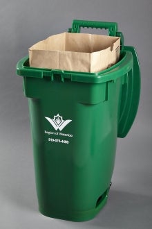 Green bin with paper bag inside