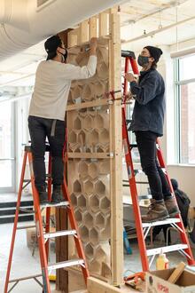 Graduate researcher James Clarke-Hicks and co-op student B. Mingyuan Ma work on the honeycomb wall, which required digital and physical iterations and multiple assembly mockups.