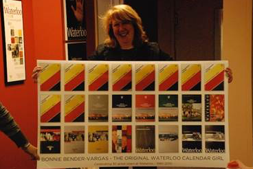 Bonnie Bender-Vargas holds up a collage of academic calendars she was responsible for creating.