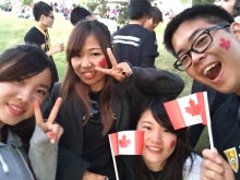 Students at the Canada Day celebration waving miniature Canadian flags.